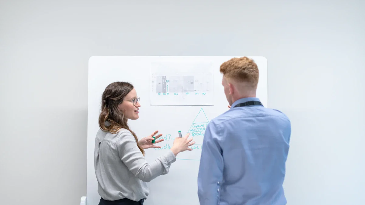 Two colleagues discussing a technical plan together at a whiteboard.