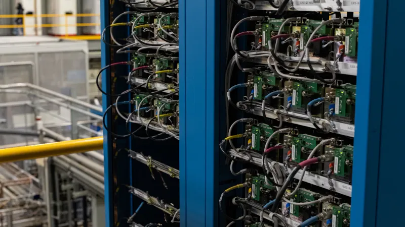 Server racks containing electronic components, connected cables and computing equipment.